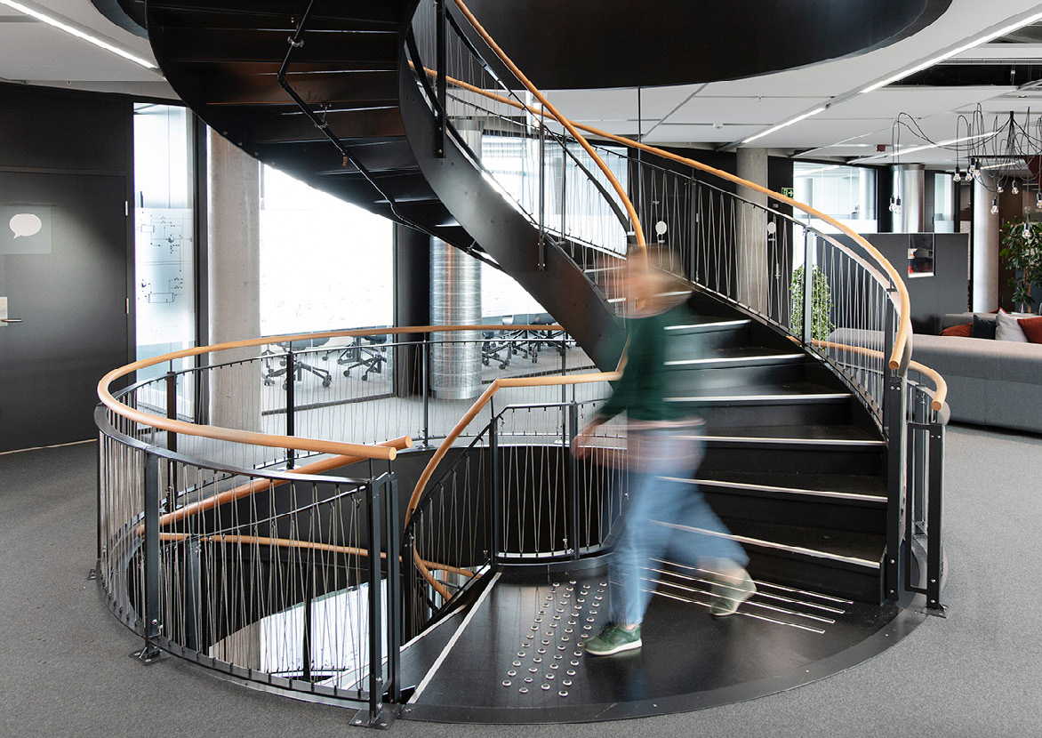 Person walking down spiral staircase in Entra offices