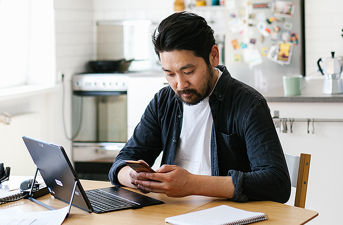 Employee working from home looking at phone