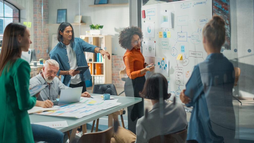 Tech employees collaborating on whiteboard