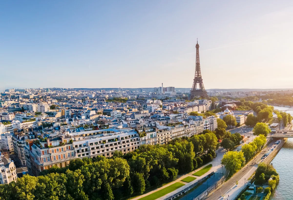 Paris aerial panorama with river Seine and Eiffel tower, France. Romantic summer holidays vacation destination. Panoramic view above historical Parisian buildings and landmarks with blue sky and sun