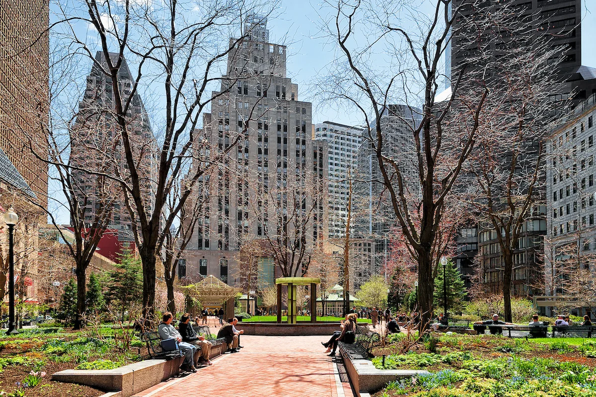 Boston, USA - April 28, 2015: People at Post Office Square and Skyline with Skyscrapers of downtown Boston, MA, USA.