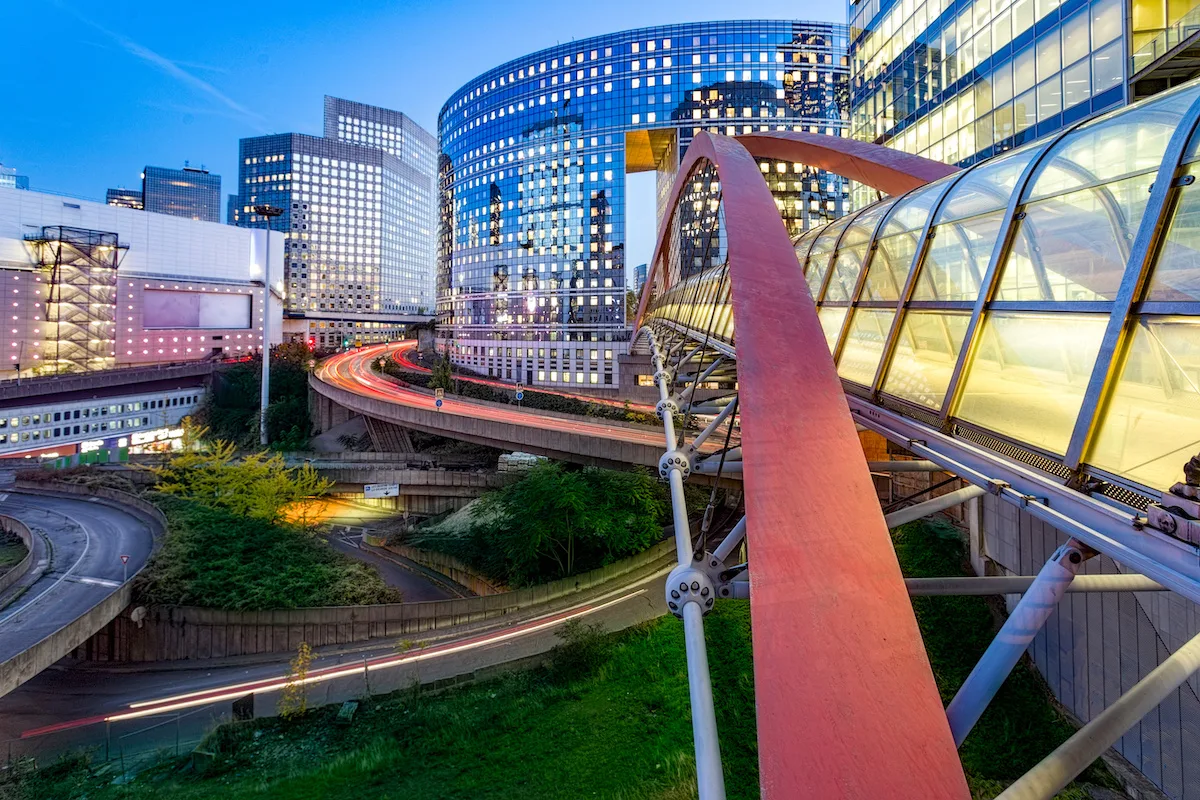 Sunset and Illuminated bridge linking two building together at La Defense, the European largest business district located in West of Paris, France