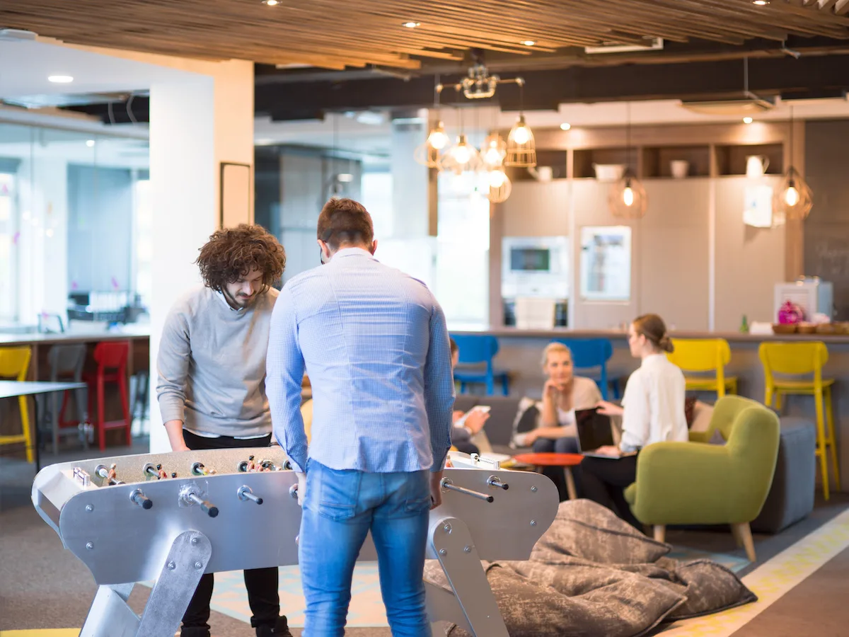 Startup Office People Enjoying Table Soccer Game During their Free Time at the creative Workplace